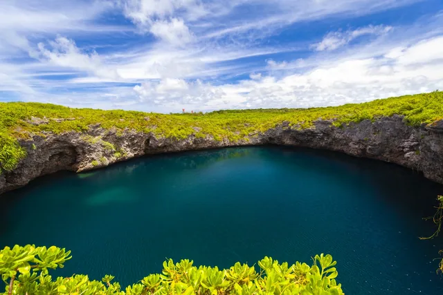 Deep blue water surrounded by limestone and greenery at Toriike on Shimoji Island