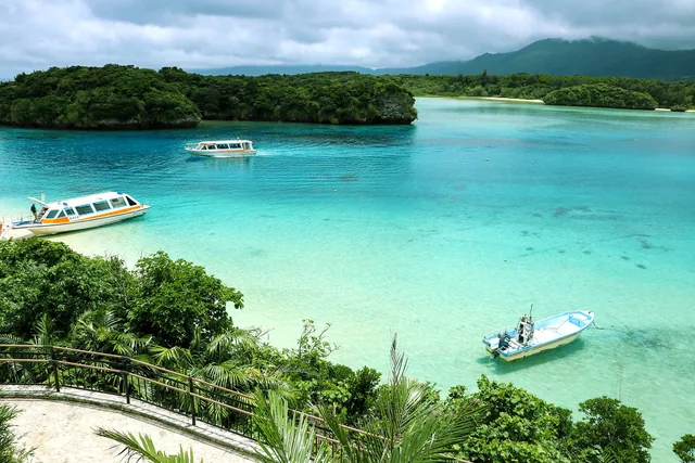 川平湾の透明なエメラルド色の海とグラスボート